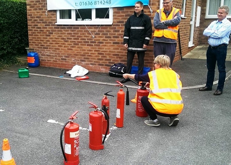 Staff gaining practical experience using water and CO2 fire extinguishers